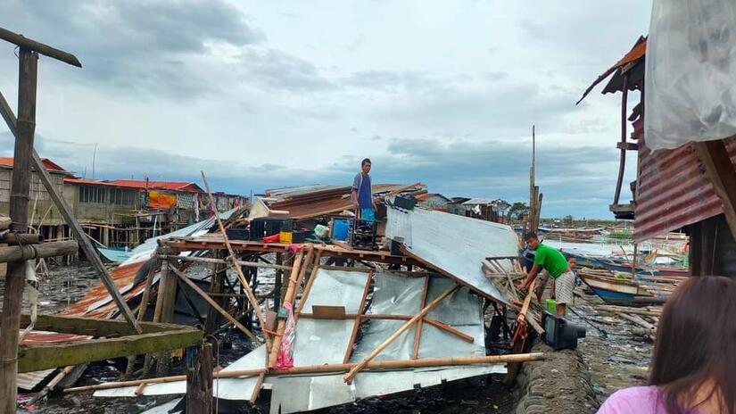 A man stands on his devastated home after Typhoon Rai slammed into the east coast of the Philippines. Photo: Philippine Red Cross