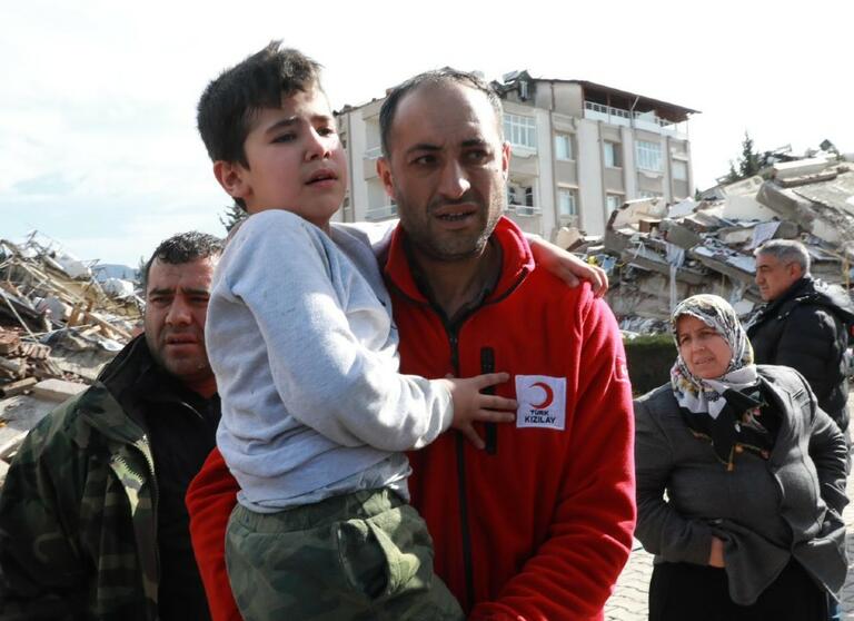 A Turkish Red Crescent (TRC) member helped a child in the disaster/ TRC